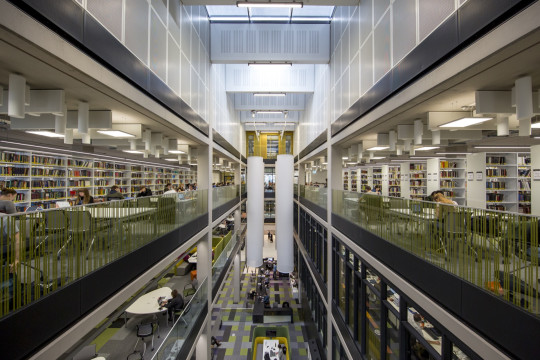 Interior view: View overlooking the Helpdesk and reception showing the large sound baffles, study areas and shelving/stock.