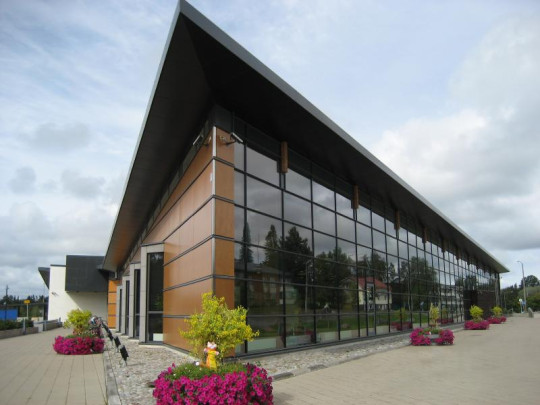 The entrance is in the corner on the left, by the white wall. -