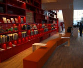 Red bookcase which goes from first to third floor